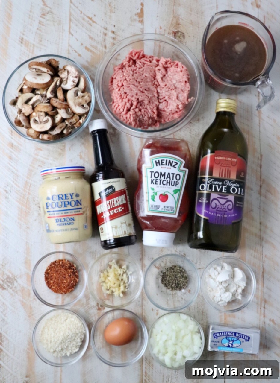 A collection of fresh ingredients for Salisbury Steak laid out on a white wooden board, including ground beef, mushrooms, onions, and various spices.