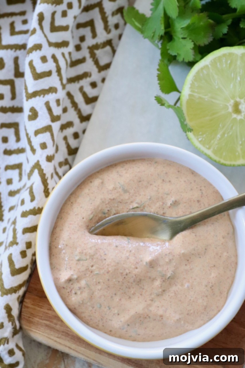 Creamy homemade Southwest Salad Dressing in a small bowl with a spoon, garnished with fresh cilantro.