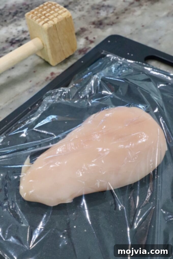 Vibrant Southwest Salad 5 chicken breast on cutting board covered with plastic wrap