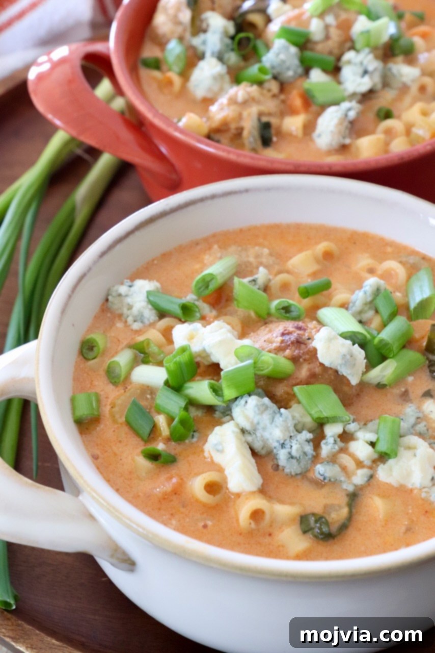 Bold Buffalo Chicken Soup 9 Three bowls of buffalo chicken soup, topped with fresh garnishes like green onions and blue cheese crumbles.