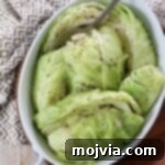 A close-up of tender steamed cabbage in a serving dish, garnished and ready to be served, highlighting its fresh appearance.