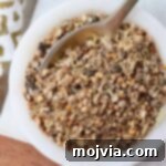 Homemade corned beef seasoning in a small bowl with a tiny spoon, ready for use.