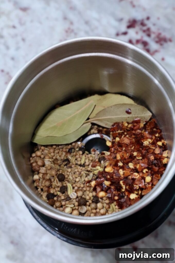 Signature Corned Beef Spice Blend 5 Toasted whole spices, along with bay leaves and crushed red pepper flakes, placed inside a spice grinder, ready to be pulsed into a coarse seasoning blend for corned beef.