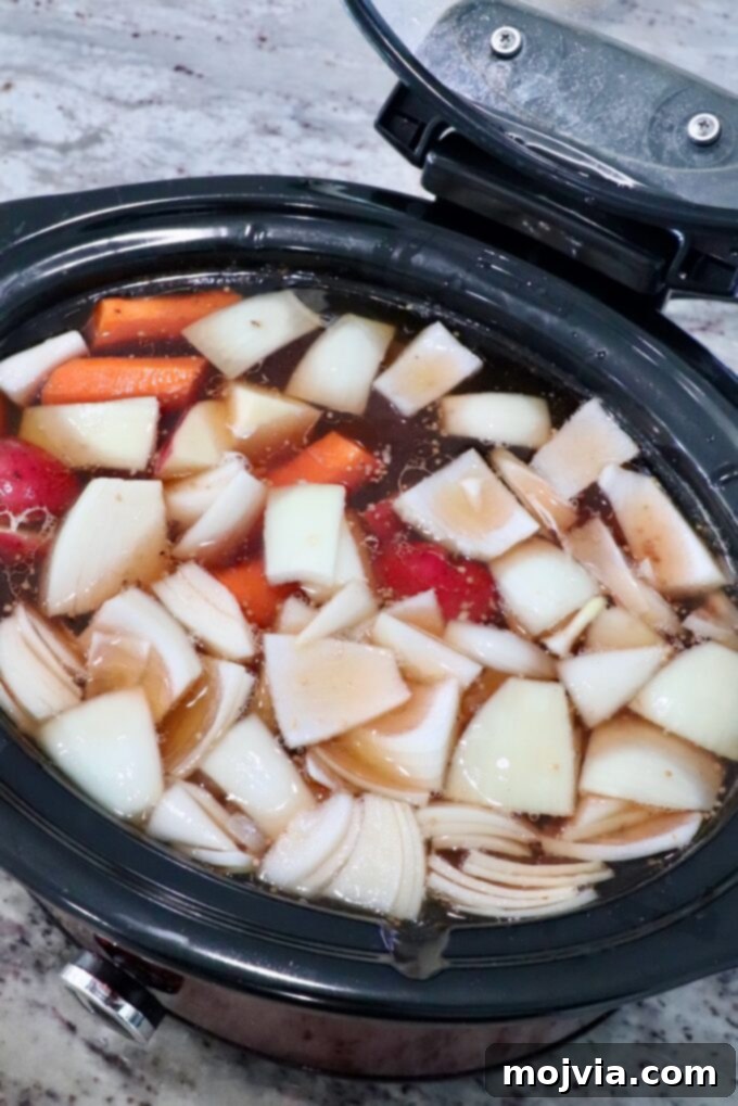 vegetables in crock pot with beef broth and brisket