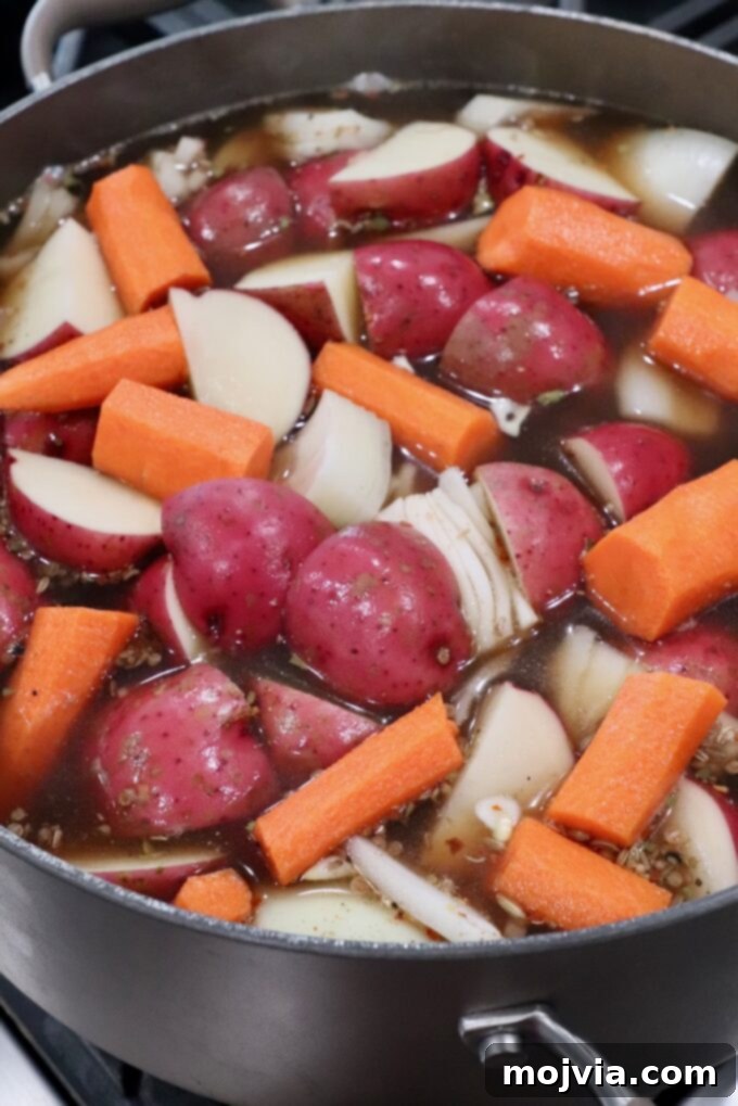 carrots, onions and red potatoes in beef broth in dutch oven