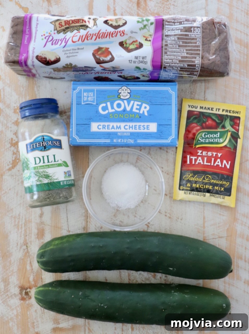 Delicate Cucumber Delights 3 Ingredients for Zesty Cucumber Sandwiches laid out on a white wood board