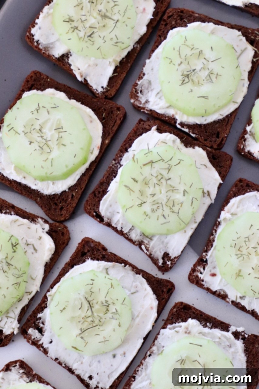 Delicate Cucumber Delights 8 Small open-faced cucumber sandwiches artfully arranged on a white plate.