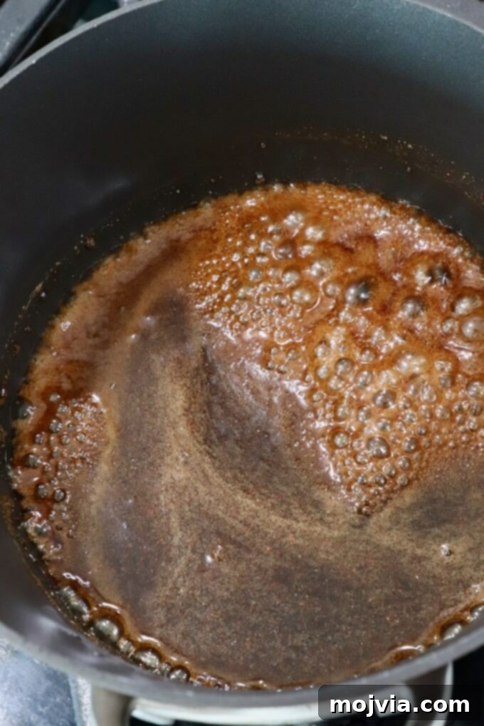Golden Honey Glazed Ham Feast 9 Brown sugar glaze simmering in a saucepan on the stove.