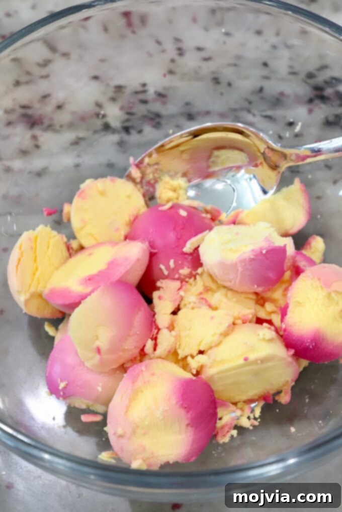 The mashed yolks from beet-pickled hard-boiled eggs in a glass bowl, ready for filling.