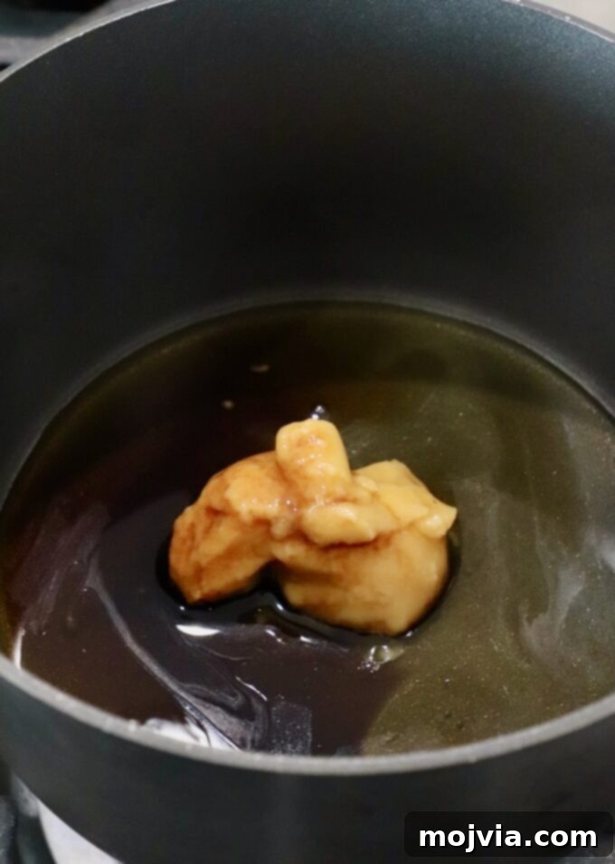 Golden Glazed Miso Salmon 4 miso paste in a small pot on the stove with sesame oil, honey, mirin and soy sauce