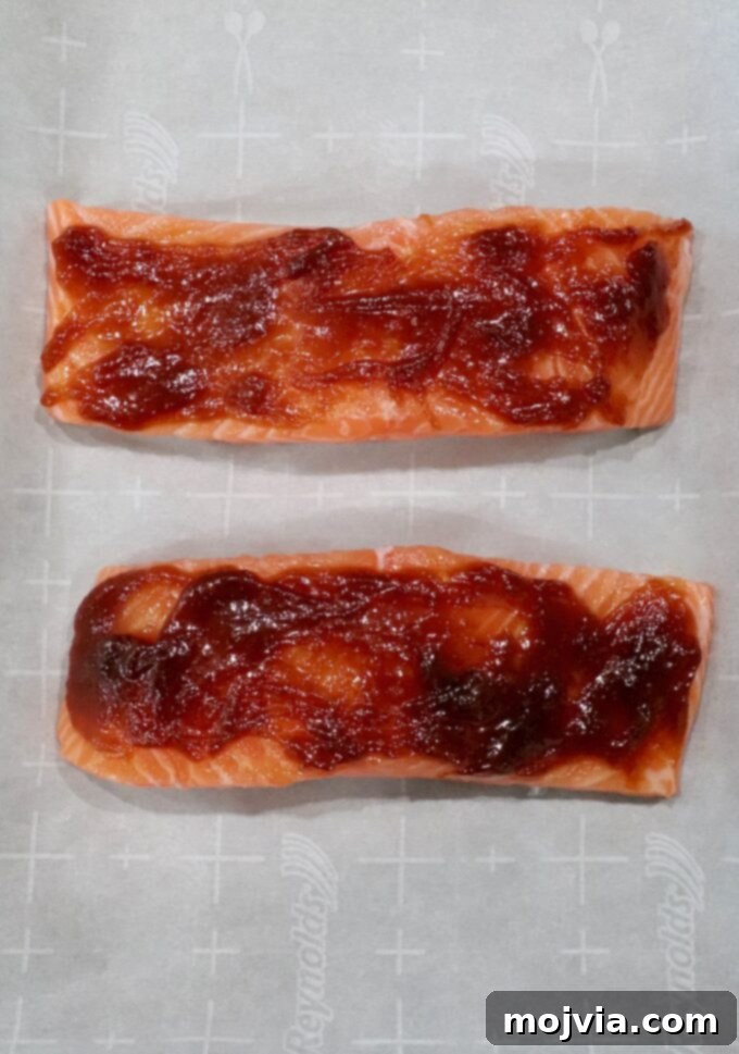 Golden Glazed Miso Salmon 7 salmon filets on parchment lined baking sheet topped with miso glaze