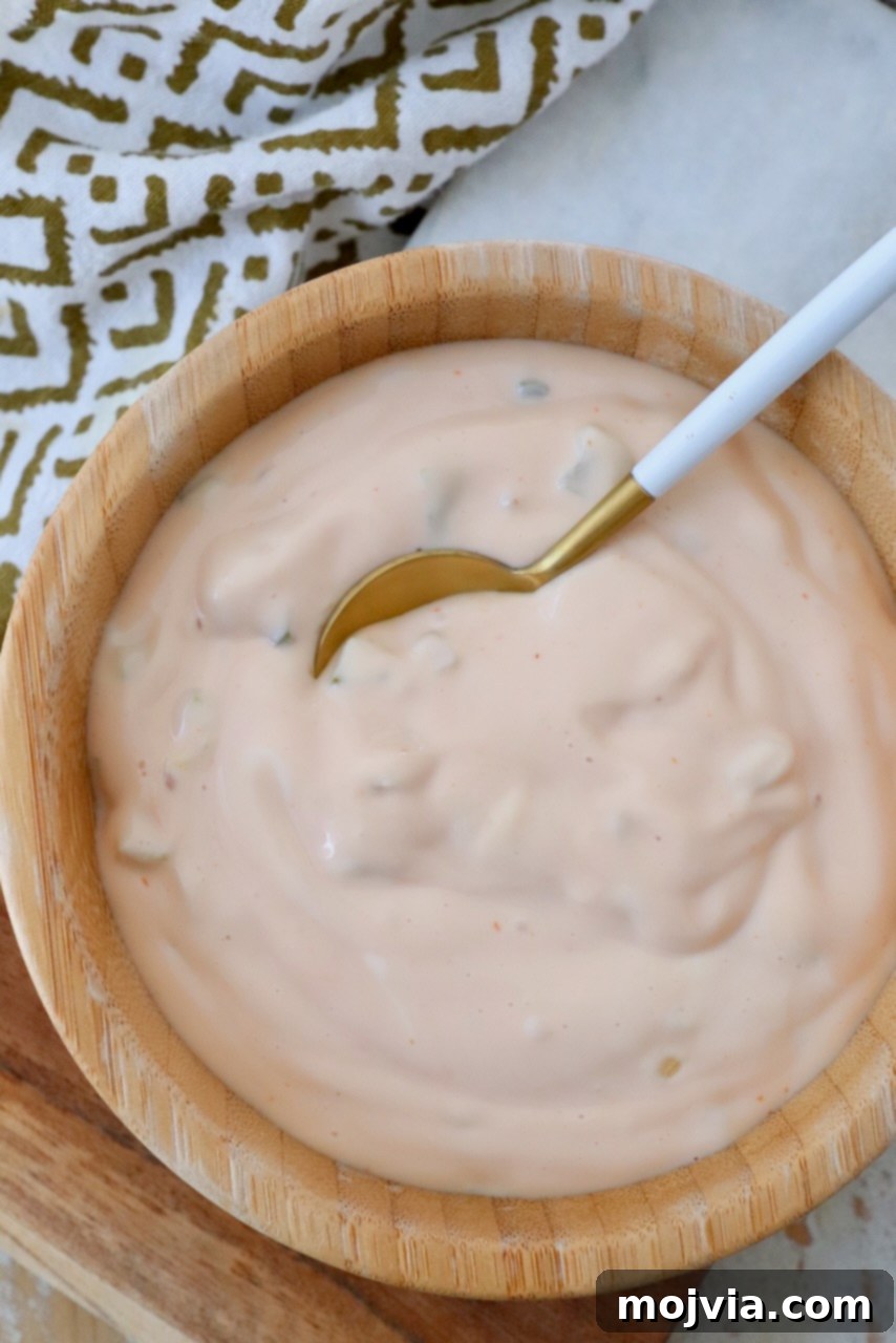 Secret Burger Sauce 7 A bowl of freshly made burger sauce with a small spoon, showcasing its rich texture and inviting color, ready for serving