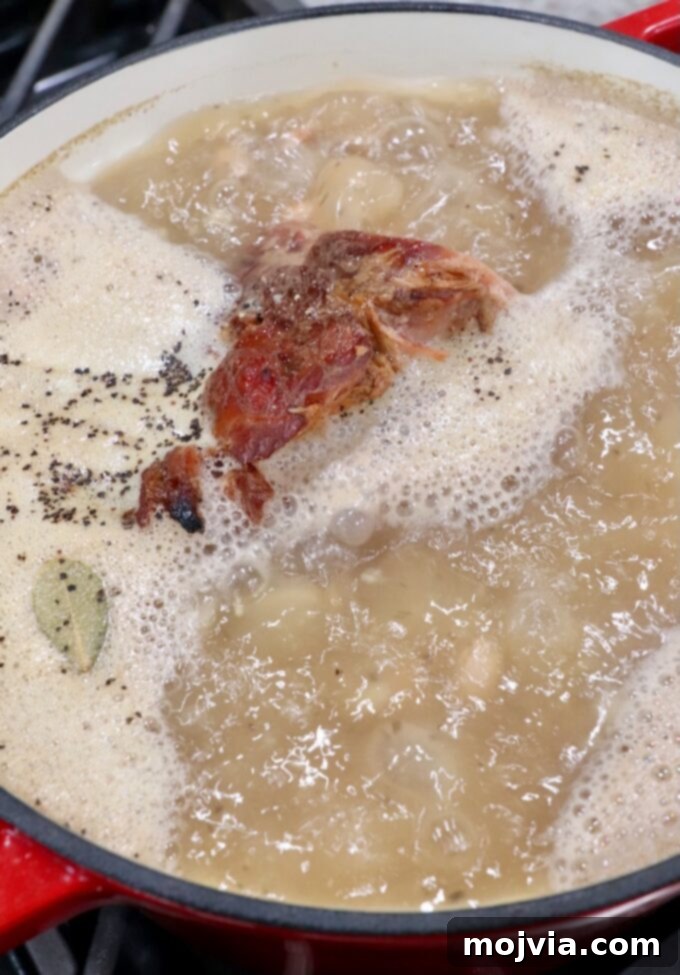 The Humble Pinto: A Culinary Staple 7 ham bone simmering in liquid in pot