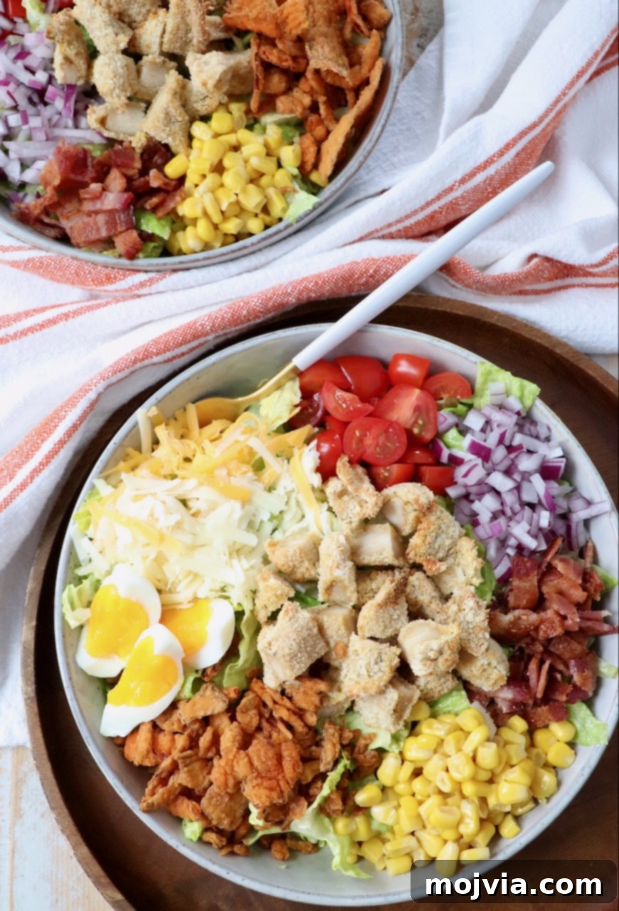 Two bowls of Crispy Chicken Salad side-by-side, garnished with all the fresh and crispy toppings, ready for serving.