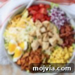 Crispy Chicken Salad in a bowl topped with golden chicken, corn, cheese, bacon, and fresh vegetables