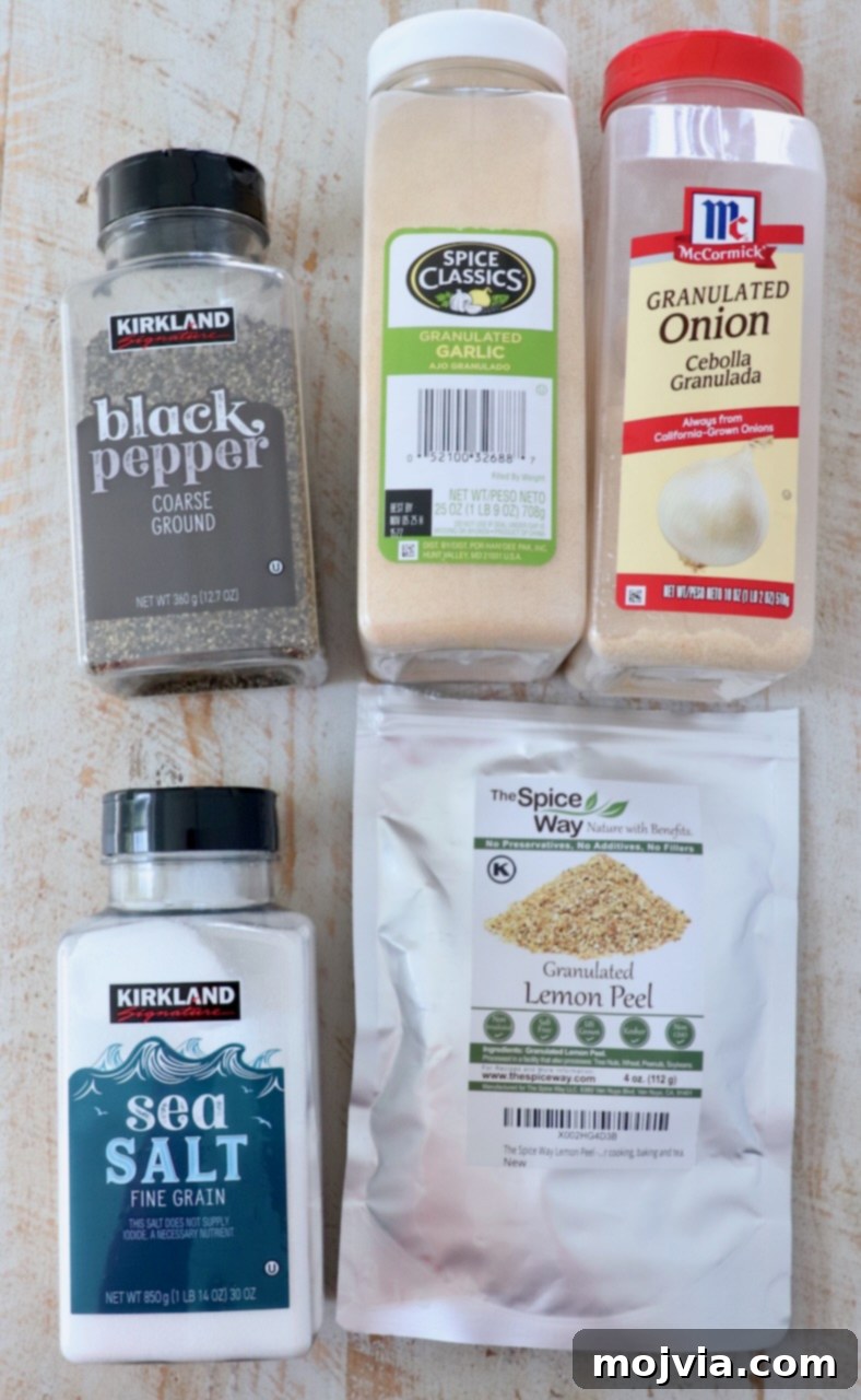 Zesty Lemon Pepper Blend 3 Carefully arranged ingredients for lemon pepper seasoning displayed on a pristine white wooden board, showcasing their fresh quality and vibrant colors.
