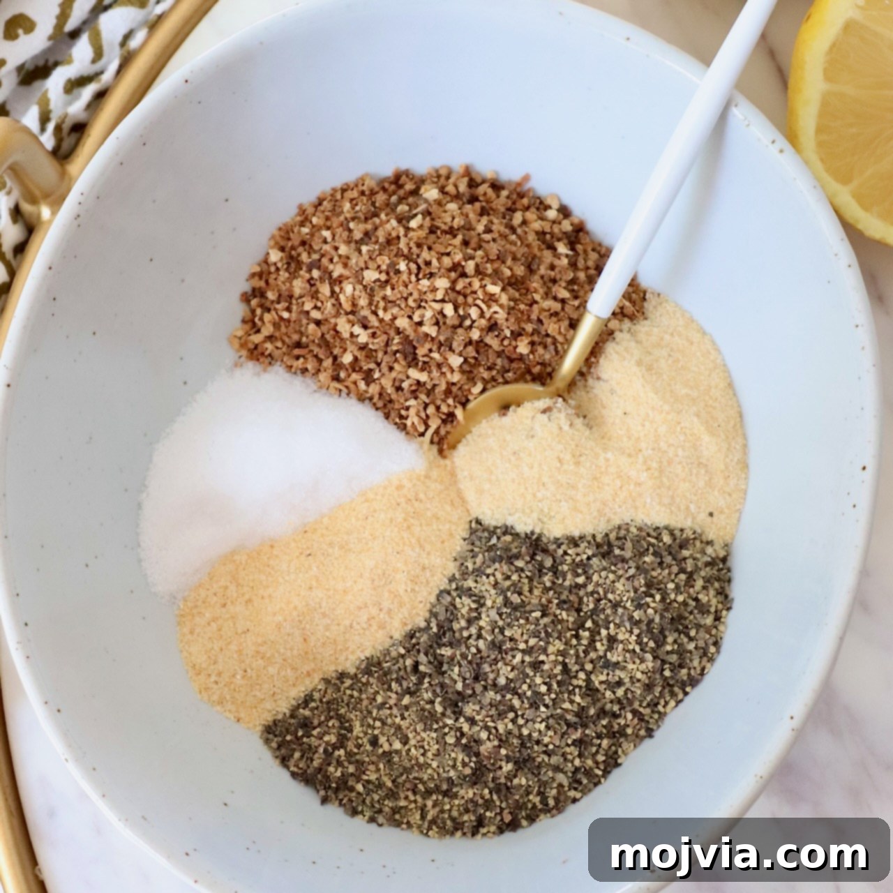 Zesty Lemon Pepper Blend 4 A vibrant display of separated spices within a bowl, each distinct ingredient awaiting its mix to become the perfect lemon pepper seasoning.