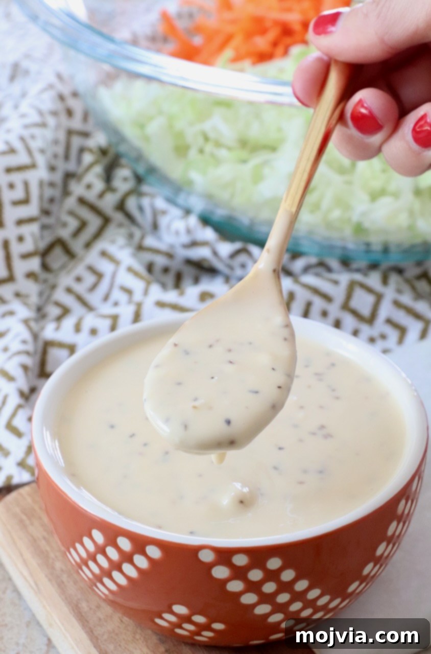 Zesty Coleslaw Dressing 2 Homemade coleslaw dressing in a small white bowl with a spoon