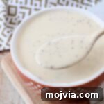 Zesty Coleslaw Dressing 8 Coleslaw dressing in a bowl with a spoon, ready to be served