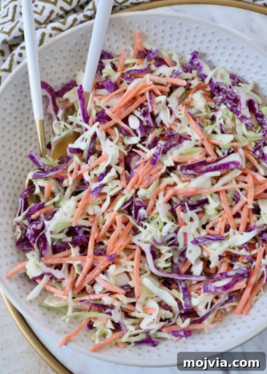Zesty Coleslaw Dressing 7 Prepared coleslaw in a large glass bowl with serving spoons