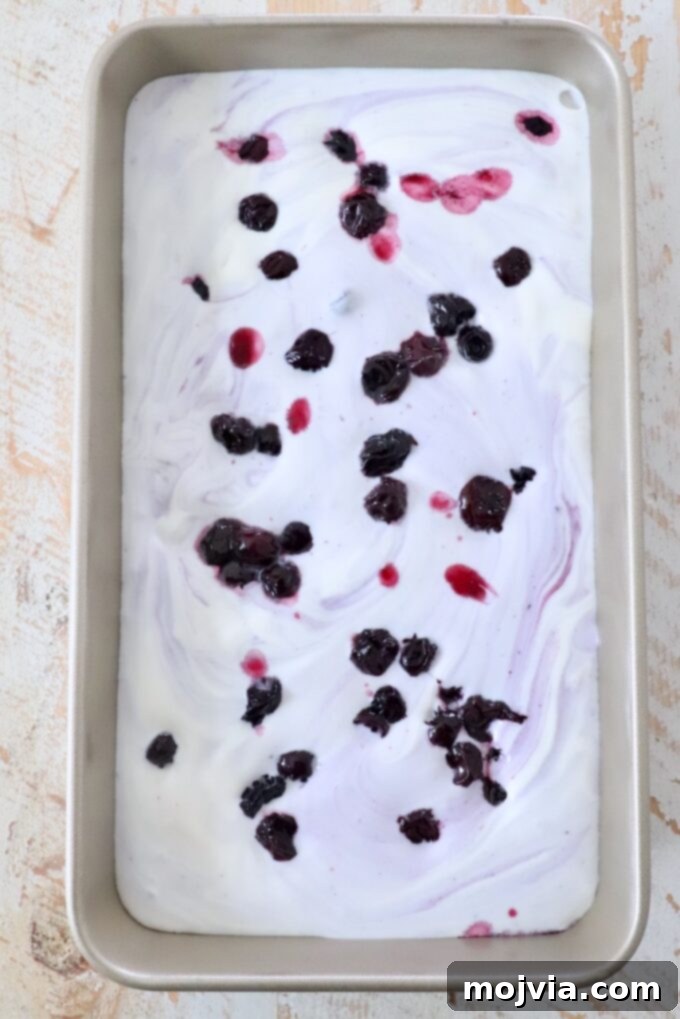 Frosted Blueberry Dream 9 Homemade blueberry ice cream mixture poured into a metal container, ready to be covered and placed in the freezer to set.