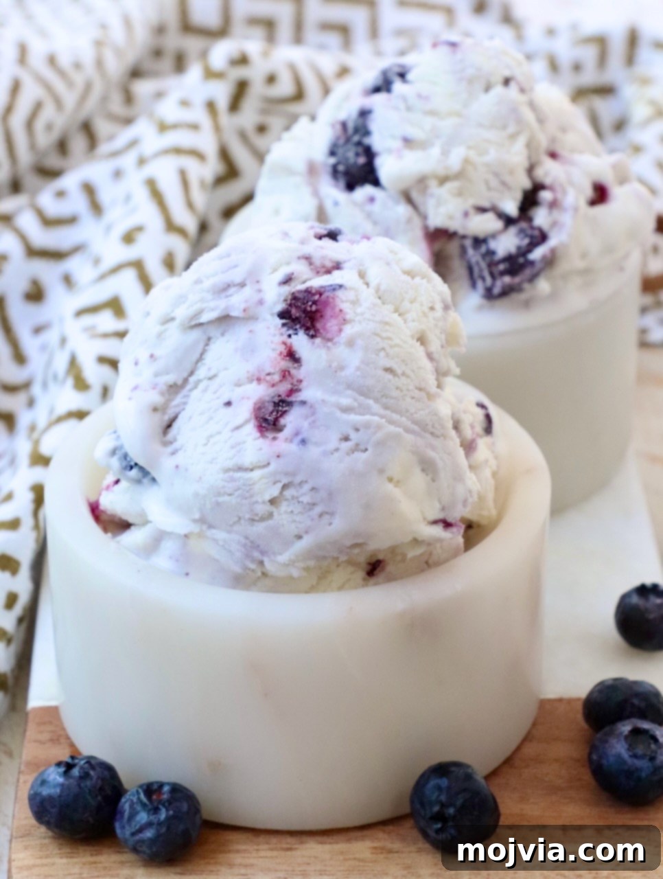 Frosted Blueberry Dream 10 Several small bowls filled with scoops of homemade blueberry ice cream, ready to be served, highlighting the delicious texture and vibrant color.