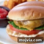 cheeseburger on plate with a side bowl of ketchup
