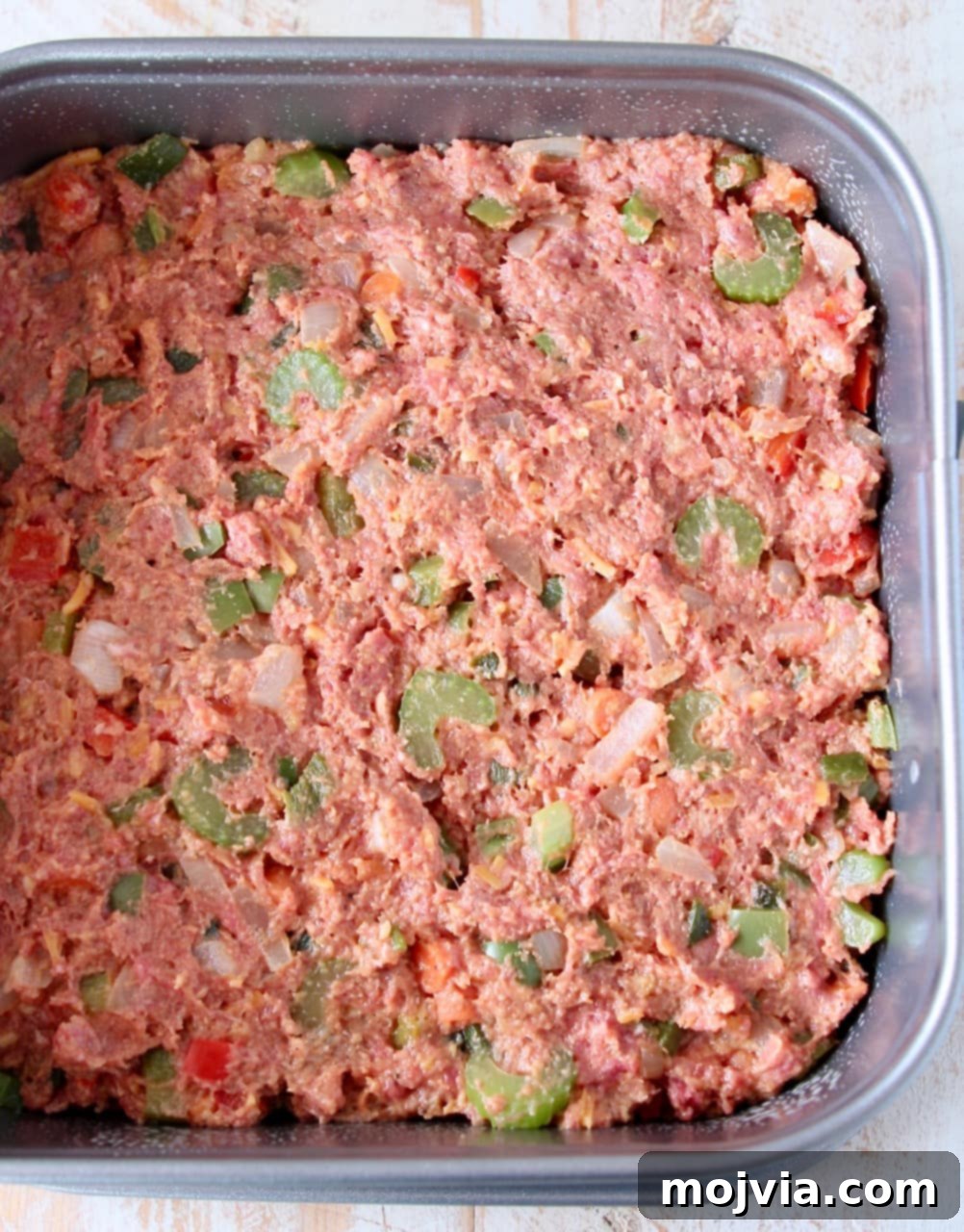 Uncooked mexican meatloaf in square springform pan