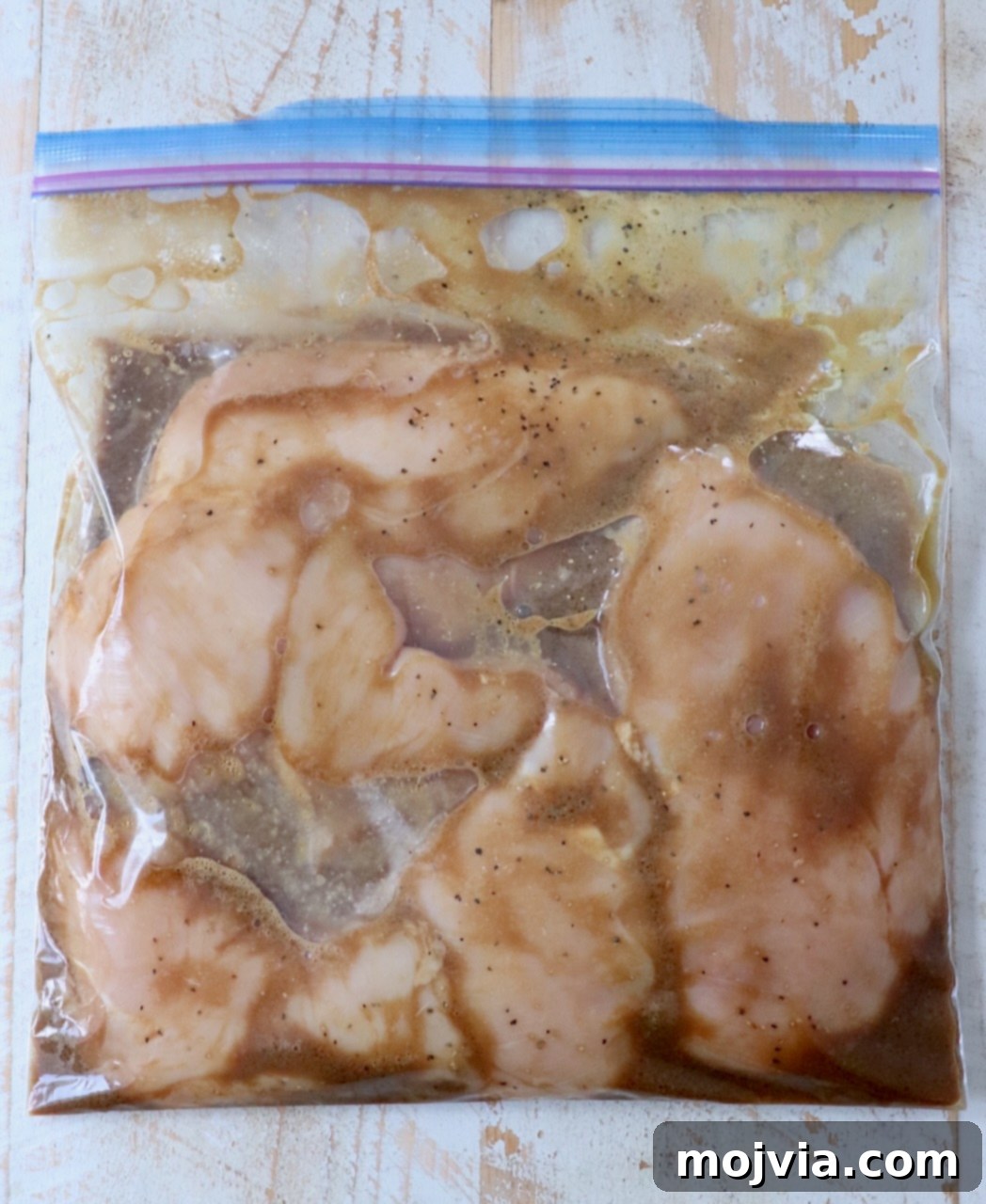 Tender Chicken Elixir 4 Chicken breasts soaking in the prepared marinade inside a plastic zipper bag, ready for refrigeration.