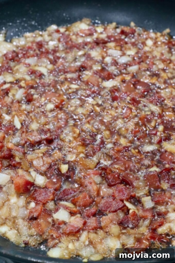 Sweet & Savory Bacon Preserve 11 Bacon jam simmering gently in a skillet, reducing and thickening into a rich, glossy consistency.