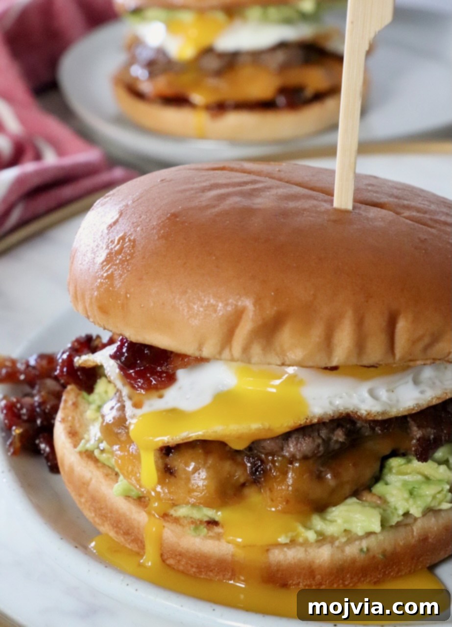 Sunrise Burger 2 Gourmet Breakfast Burger with a fried egg and runny yolk on a plate, ready to be enjoyed.