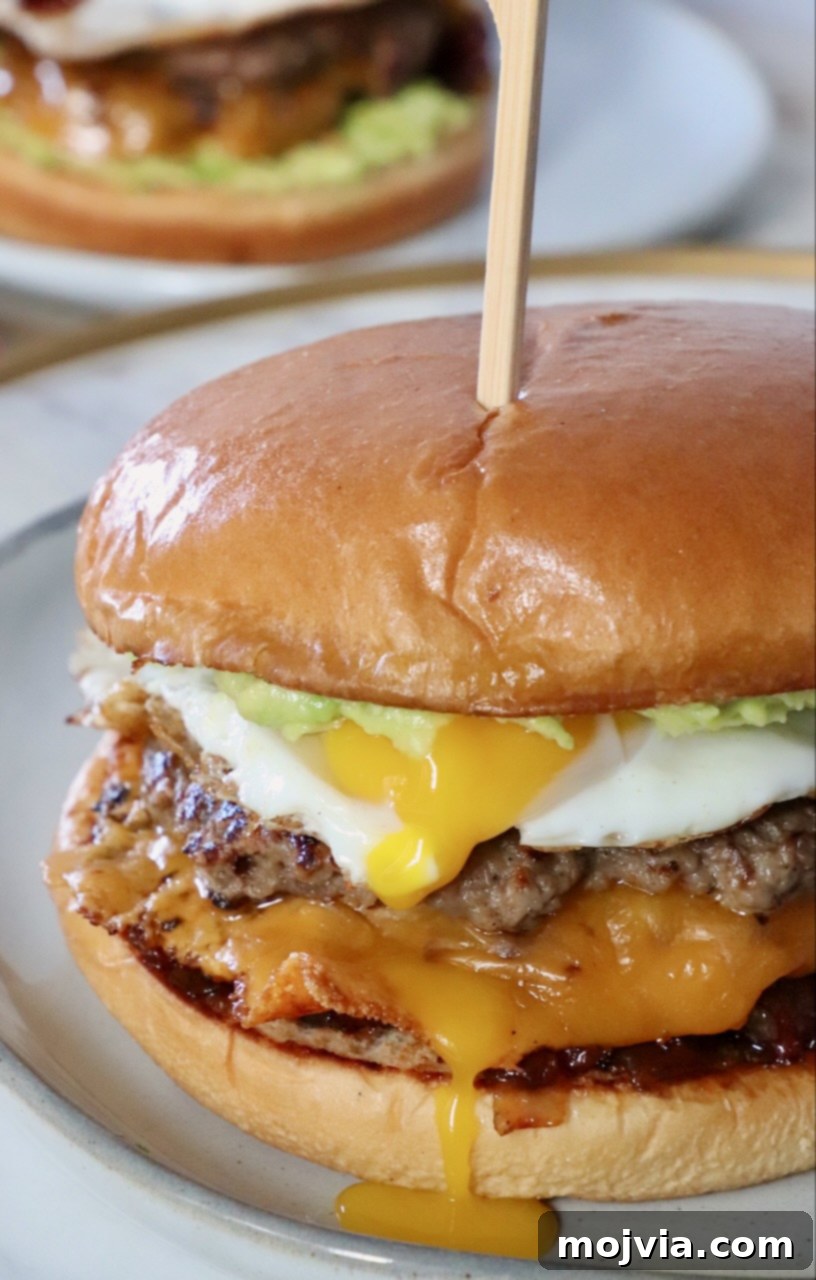 Sunrise Burger 14 A delectable cheeseburger topped with a perfectly fried egg and rich bacon jam, served on a plate.