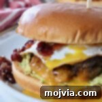 Sunrise Burger 15 Gourmet Breakfast Burger with a fried egg and bacon jam on a plate.