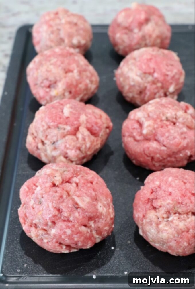 Sunrise Burger 4 Balls of mixed ground beef and breakfast sausage on a cutting board, ready to be formed into patties.