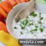 creamy vegetable dip in bowl topped with fresh chopped dill