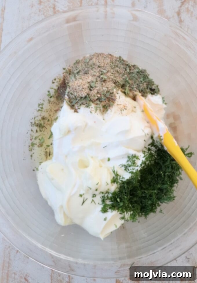Garden Vegetable Dip 4 ingredients for vegetable dip in large glass bowl with yellow spatula
