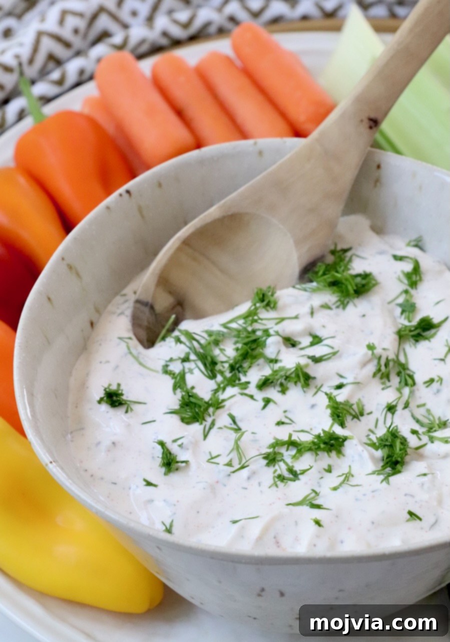 Garden Vegetable Dip 7 creamy dip topped with chopped dill in bowl with spoon
