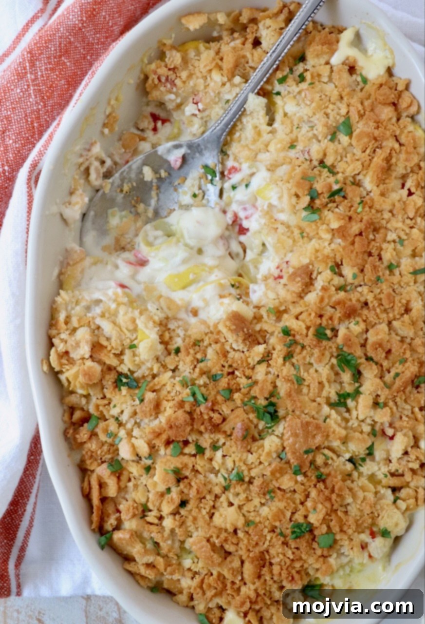 Golden Cheesy Squash Bake 2 Golden brown squash casserole topped with a crispy Ritz cracker crust, served in a baking dish with a serving spoon.