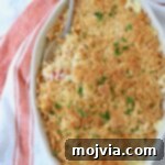 Squash casserole in baking dish with serving spoon