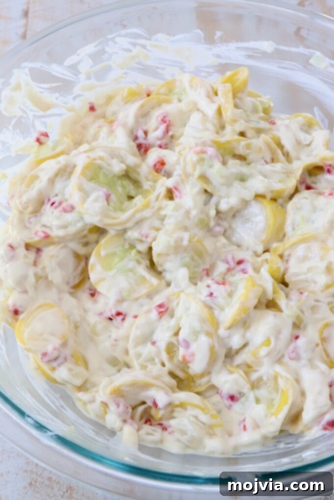 Golden Cheesy Squash Bake 9 Drained, cooked yellow squash and onions being gently folded into the creamy sour cream and soup mixture.