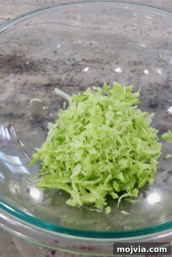 Vibrant Broccoli Slaw 6 Bowl filled with freshly shredded broccoli stems, showcasing the texture for the slaw.