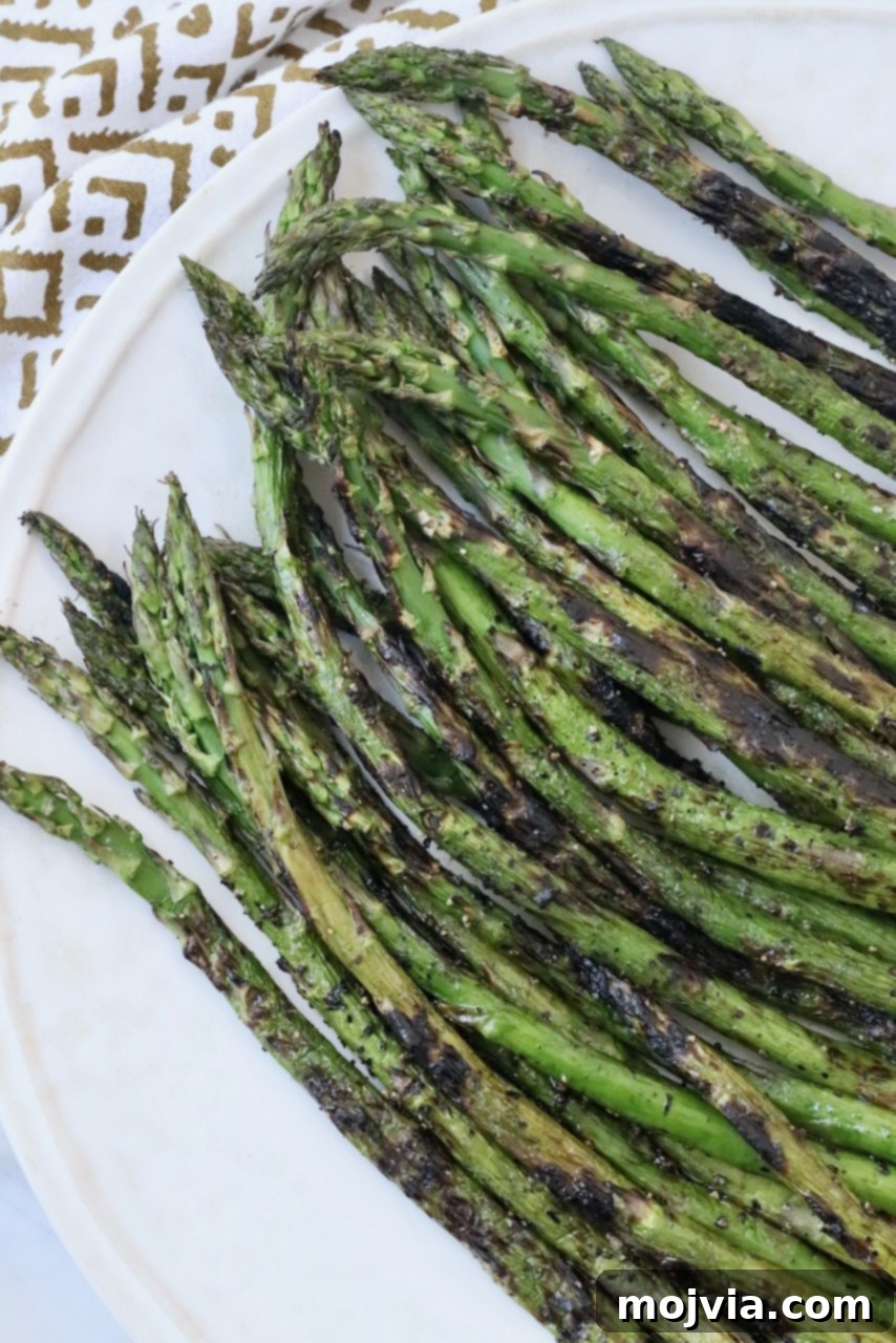 Simple Steps to Delicious Asparagus 2 Grilled asparagus spears elegantly arranged on a serving plate, ready to be enjoyed.