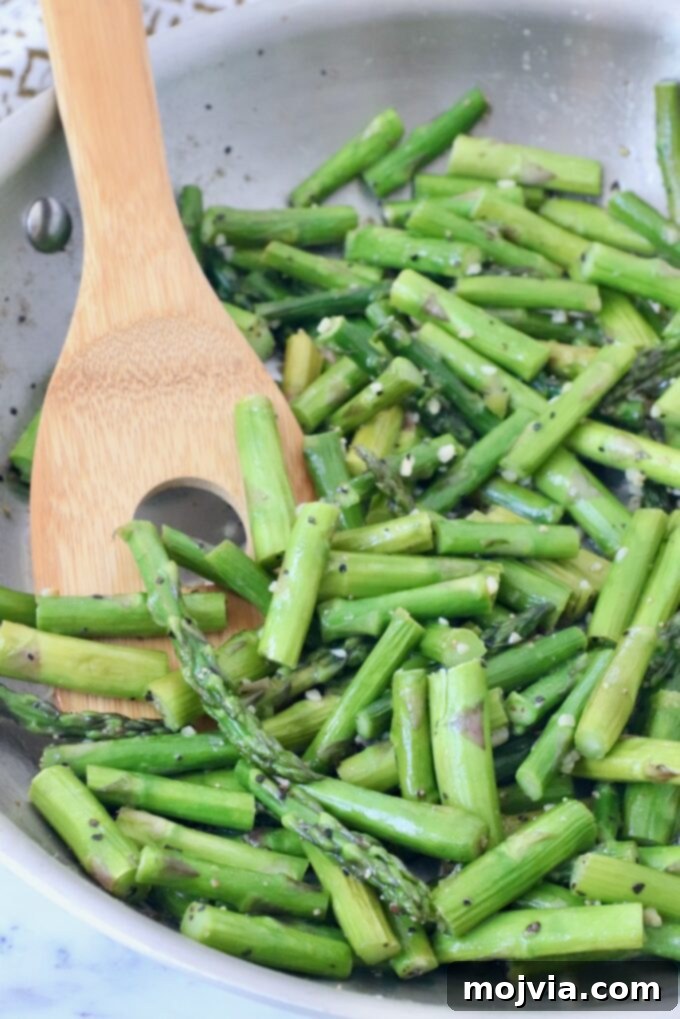 Simple Steps to Delicious Asparagus 11 Cooked asparagus in a skillet, ready to be served with a spoon.