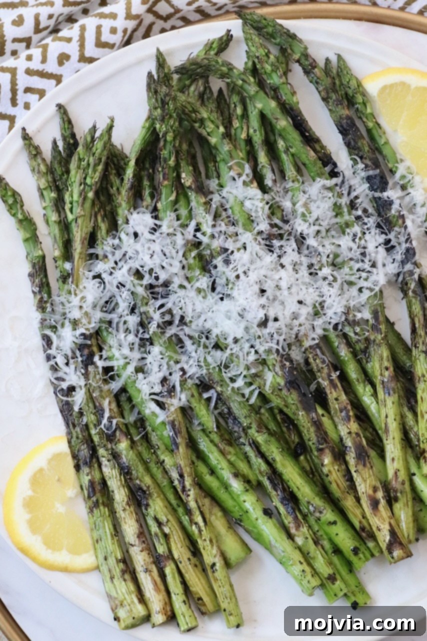 Simple Steps to Delicious Asparagus 12 Grilled asparagus topped with a generous sprinkle of grated parmesan cheese, served on a plate.