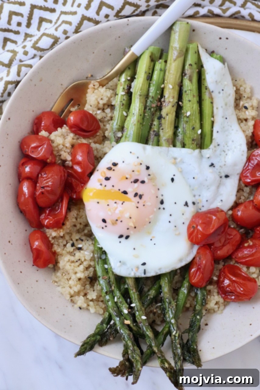 Simple Steps to Delicious Asparagus 13 Cooked asparagus presented in a vibrant bowl with roasted tomatoes, fluffy quinoa, and a perfectly fried egg, illustrating a balanced meal.