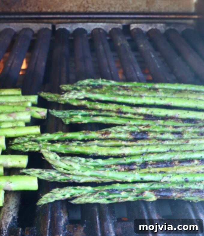 Simple Steps to Delicious Asparagus 5 Fresh asparagus spears cooking on a hot grill, showing early char marks.