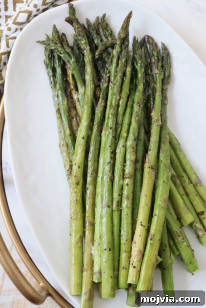Simple Steps to Delicious Asparagus 8 Perfectly roasted asparagus spears served on a simple white plate.