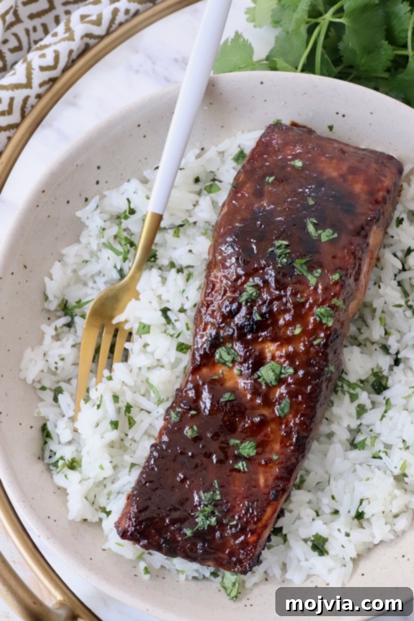 glazed salmon on top of rice in bowl with fork