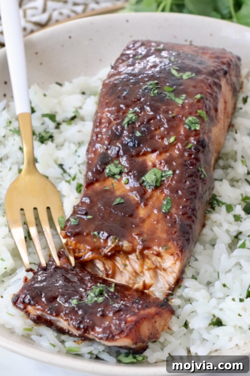 cooked glazed salmon in bowl with rice and fork