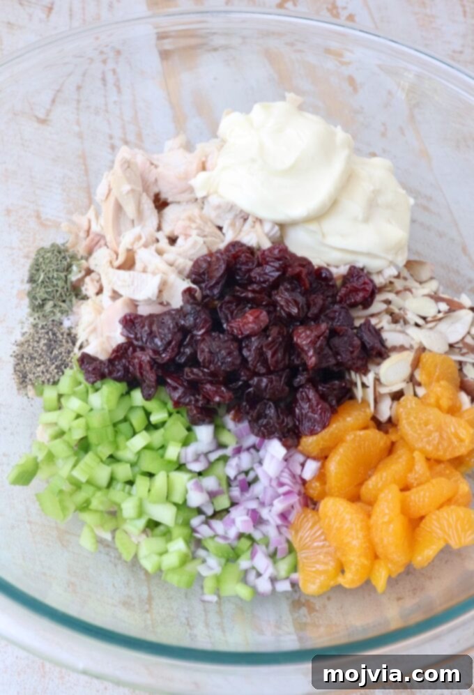 Garden Chicken Medley 4 individual ingredients for chicken salad in separate sections of a large glass bowl, ready to be mixed